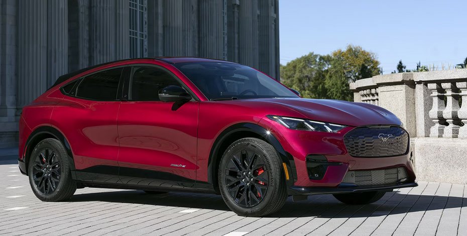 Ford Mustang Mach-E electric SUV in vibrant red driving on a scenic highway