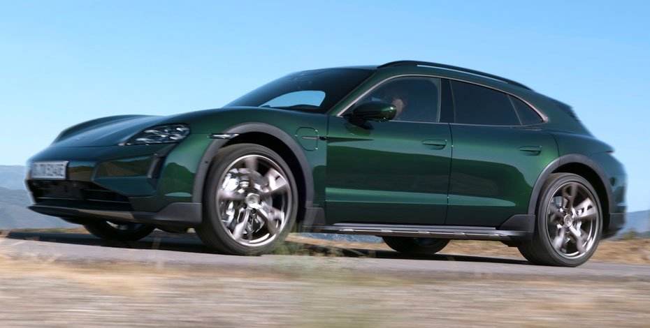 Side profile of a green Porsche Taycan Turbo S luxury electric sports car with aerodynamic design and premium alloy wheels